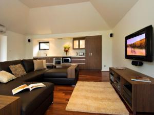 a living room with a couch and a flat screen tv at Chandeliers on Abbey in Yallingup