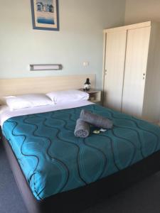 a hotel room with a bed with a towel on it at Merimbula Gardens Motel in Merimbula