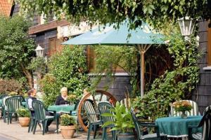 Ein paar Leute sitzen mit einem Regenschirm an einem Tisch. in der Unterkunft Onkel Tom`s Hütte in Göttingen