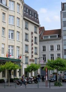 een groep gebouwen in een stadsstraat met mensen bij Hotel Windsor in Brussel