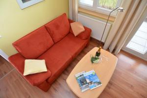 オストゼーバート・ゼリンにあるVilla Seerose - Appartement 13のリビングルーム(赤いソファ、テーブル付)