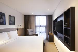 A bed or beds in a room at GLAD Gangnam COEX Center