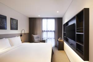 a hotel room with a bed and a flat screen tv at GLAD Gangnam COEX Center in Seoul