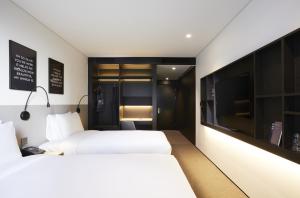 a hotel room with two beds and a tv at GLAD Gangnam COEX Center in Seoul