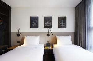 two beds sitting next to each other in a room at GLAD Gangnam COEX Center in Seoul