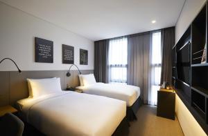 a hotel room with two beds and a television at GLAD Gangnam COEX Center in Seoul