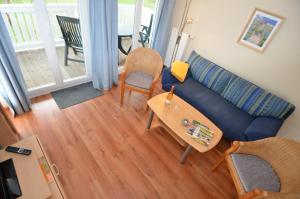 a living room with a blue couch and a table at Villa Seerose - Appartement 18 in Ostseebad Sellin