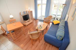 a living room with a blue couch and a table at Villa Seerose - Appartement 18 in Ostseebad Sellin