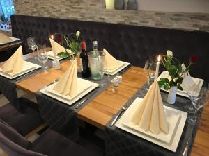 una mesa de madera con servilletas y botellas de vino. en Stadthotel Alsfeld, en Alsfeld