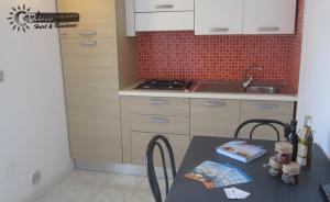 a small kitchen with a table and a sink at Appartamenti Baia Verde Gallipoli di Carlino Tourist in Gallipoli