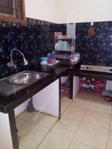 een keuken met een spoelbak en een aanrechtblad bij Azalea Homestay in Batu