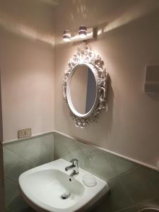 パレルモにあるBoutique House Monteverginiのバスルーム(洗面台、壁掛け鏡付)