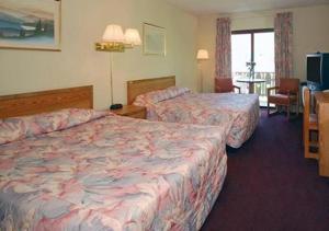 Un pat sau paturi într-o cameră la Carriage House Motor Inn