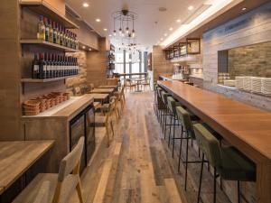 a bar with wooden tables and chairs in a restaurant at HOTEL MYSTAYS Midosuji Honmachi in Osaka