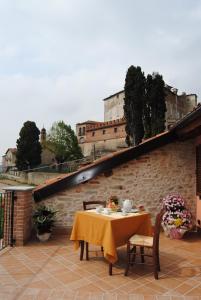 a table with a yellow table cloth on a patio at All'Ombra del Castello in Cigliè