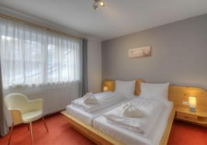 Un dormitorio con una gran cama blanca y una ventana en Kaprun Alpine Resort by Kaprun Rentals, en Kaprun