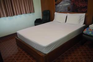 a large bed in a room with a chair at 555 Resort in Udon Thani