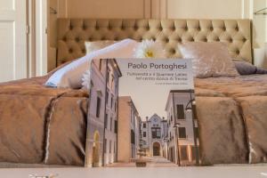 un libro en una cama con una foto de una ciudad en Suite Latina - San Leonardo, en Treviso