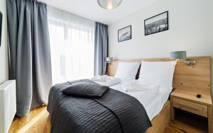 Apartamenty Sun & Snow Szklarska Perła tesisinde bir odada yatak veya yataklar