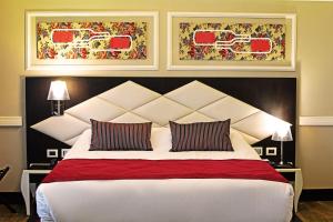 um quarto com uma grande cama branca e 2 almofadas em Hotel Sommelier Boutique em Santiago