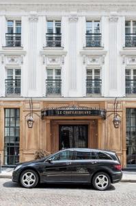 een zwarte limousine geparkeerd voor een gebouw bij Hôtel Chateaubriand in Parijs