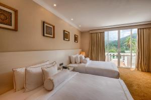 a hotel room with two beds and a large window at The Golden Crown Hotel in Kandy