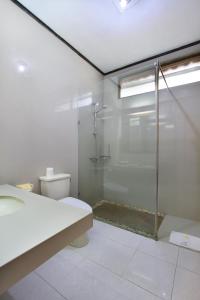 a bathroom with a glass shower and a toilet at Puri Naga Beachfront Cottages in Legian