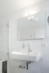 uma casa de banho branca com um lavatório e um chuveiro em Zu den Drei Linden em Wermelskirchen