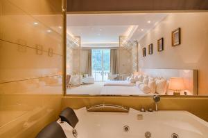 a bathroom with a tub, sink and mirror at The Golden Crown Hotel in Kandy