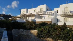 a white building with a stone wall in front of it at Villa Elena in Ornos