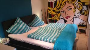 a bed with pillows and a painting of a woman at Haus Winkelchen in Cochem