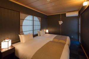 Giường trong phòng chung tại Fujinoma Machiya House