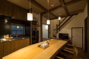 a kitchen with a large wooden table in a room at Fujinoma Machiya House in Kyoto