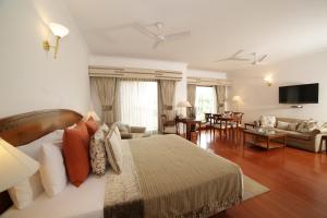 ein Schlafzimmer mit einem Bett und ein Wohnzimmer in der Unterkunft Jaypee Palace Hotel in Agra