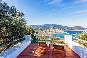 a balcony with two chairs and a view of the water at Villa Kalypso and Villa Kirki in Skopelos Town