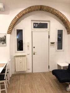a living room with a white door and an archway at San Lorenzo University flat in Rome