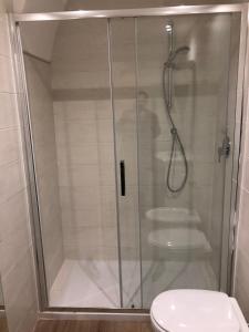 a shower with a glass door next to a toilet at San Lorenzo University flat in Rome