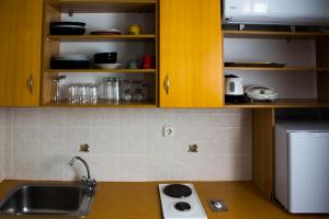 a kitchen with yellow cabinets and a sink and a stove at Bonne Nuit Pension in Nafplio