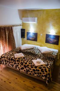 Un dormitorio con una cama con estampado de leopardo y dos toallas. en Bonne Nuit Pension, en Nauplia