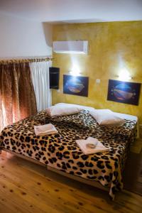 a bedroom with a leopard print bed with two towels on it at Bonne Nuit Pension in Nafplio