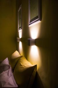 a bedroom with a bed with a light on the wall at Bonne Nuit Pension in Nafplio