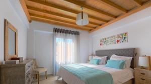 een slaapkamer met een bed en een houten plafond bij Modus Vivendi Villas in Akrotiri