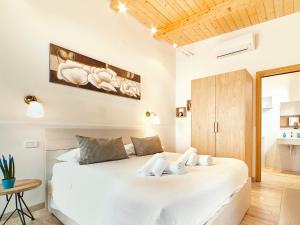 una camera da letto con un grande letto bianco e un soffitto in legno di Gli Aranci ad Agropoli