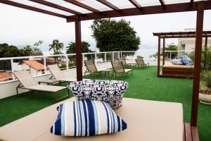 eine Terrasse mit Stühlen und einem Tisch auf dem Dach in der Unterkunft Pousada Villa Di Enzo in Ubatuba