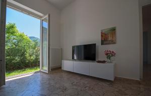 een woonkamer met een flatscreen-tv en een raam bij Vitali Apartment JR in Bellagio