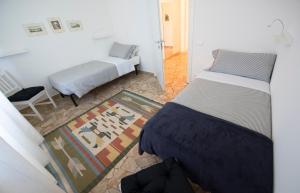 een slaapkamer met 2 bedden, een stoel en een tapijt bij Vitali Apartment JR in Bellagio