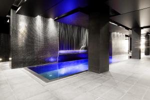 a swimming pool in a room with blue lighting at M Hotel in Łódź