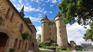 un château avec deux tours au-dessus d'un bâtiment dans l'établissement VVF Cantal Champs-sur-Tarentaine, à Champs Sur Tarentaine