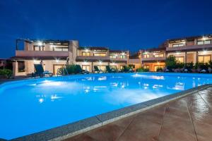 a large swimming pool in front of a building at night at Gravina Residence - Villas & Apartments in Costa Paradiso