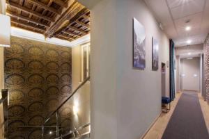 a hallway with stairs and a wall with a painting at Giuturna Boutique Hotel in Rome